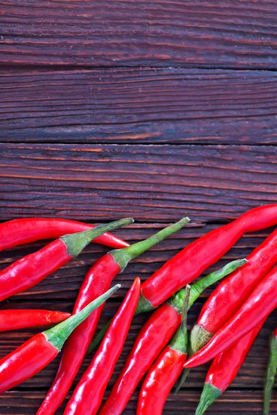 Chilli peppers on the wooden table — Stock Photo, Image