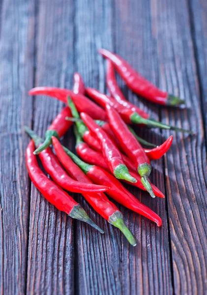 Pimentos de pimenta na mesa de madeira — Fotografia de Stock