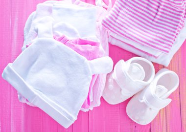 Pembe tablo üzerinde bebek giysileri