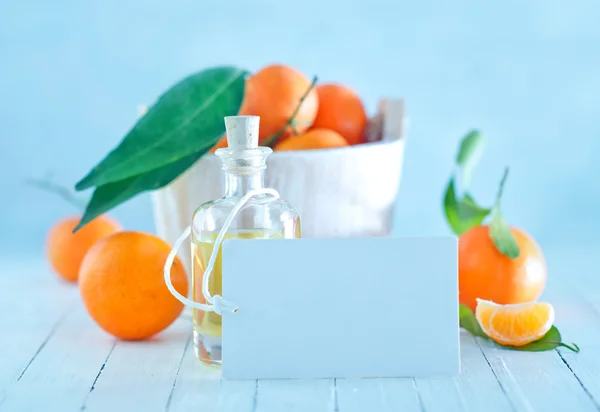 Tangerines and oil in bottle — Stock Photo, Image