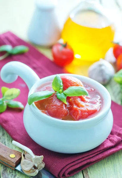 Tomate na tigela e em uma mesa — Fotografia de Stock