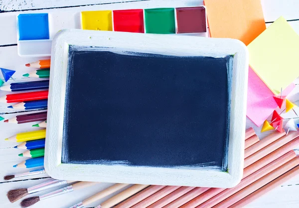 School supplies and blackboard — Stock Photo, Image