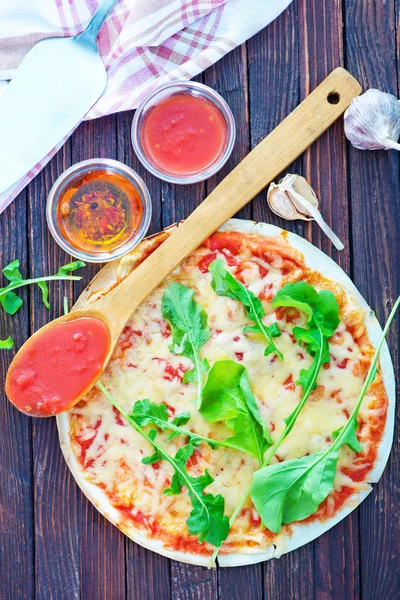 Свежая пицца на столе — стоковое фото