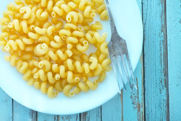 Raw pasta on white plate — Stock Photo, Image