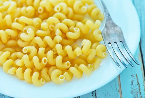 Raw pasta on white plate — Stock Photo, Image