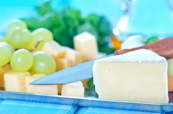 Cheese, knife and green grapes — Stock Photo, Image