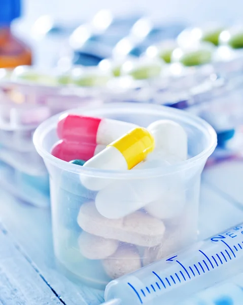 Pills and capsules on table — Stock Photo, Image