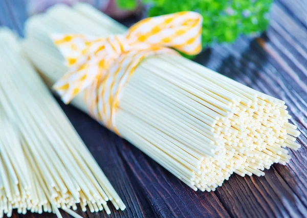 Raw pasta on wooden board — Stock Photo, Image