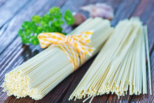 Raw pasta on wooden board — Stock Photo, Image