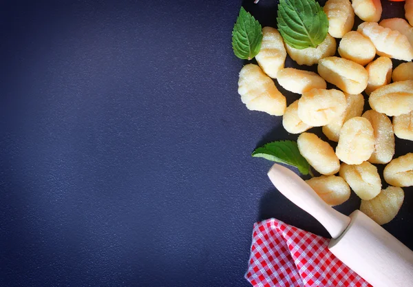 Raw gnocchi and basil leaves — Stock Photo, Image