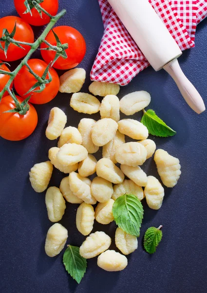 Raw gnocchi and basil leaves — Stock Photo, Image
