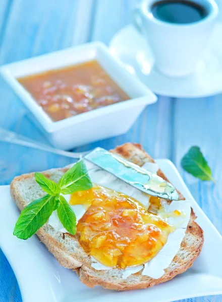 Rostat bröd med sylt på ett bord — Stockfoto