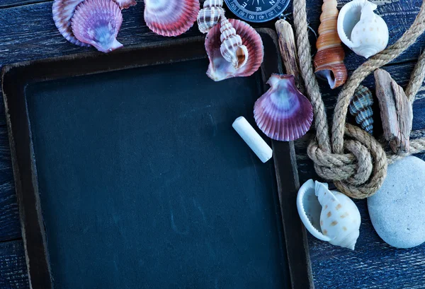 Conchas marinas y brújula sobre una mesa —  Fotos de Stock