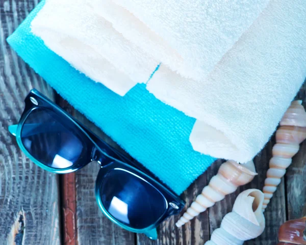 Bílé ručníky, mořské mušle a brýle — Stock fotografie