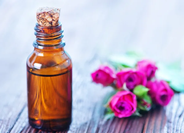 Rosenöl in der Flasche und auf dem Tisch — Stockfoto