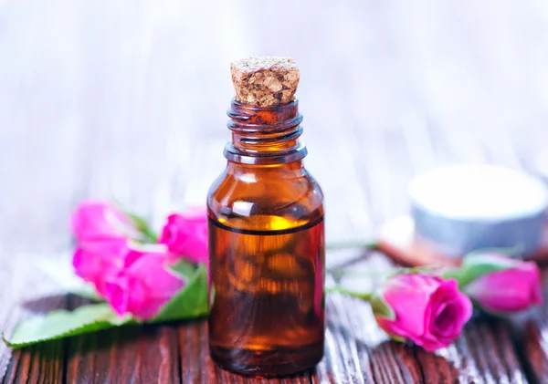 Rosenöl in der Flasche und auf dem Tisch — Stockfoto