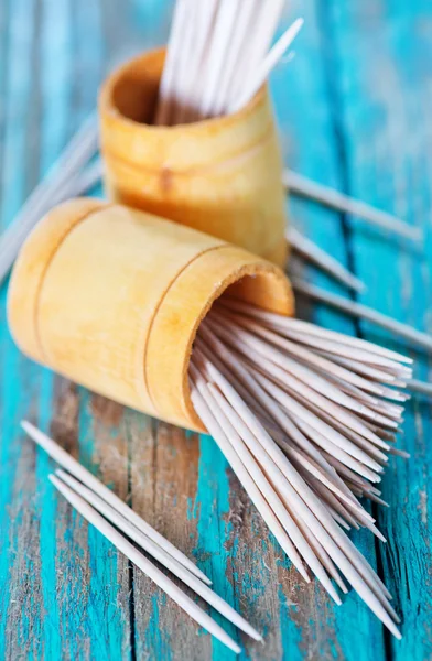 Wooden toothpicks on the green table — Stock Photo, Image