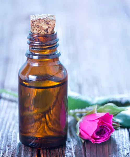 Rose oil in bottle and on a table — Stock Photo, Image