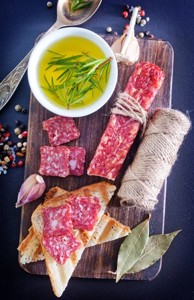 Salame e torradas no tabuleiro — Fotografia de Stock