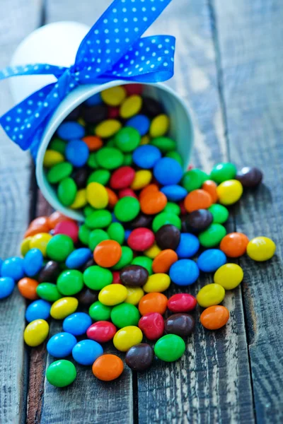 Caramelle di colore in tazza di carta — Foto Stock