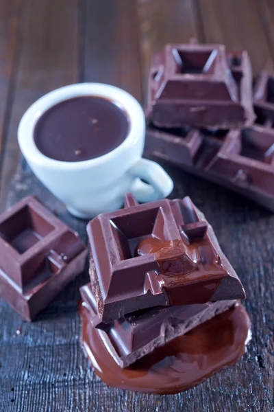 Chocolate en taza y sobre la mesa — Foto de Stock