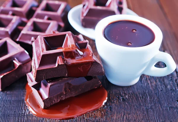 Chocolate en taza y sobre la mesa — Foto de Stock