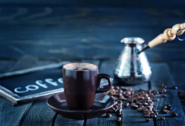 Grains de café sur la table en bois — Photo