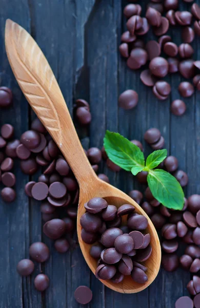 Sweet chocolate in wooden spoon — Stock Photo, Image