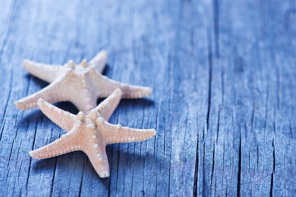 Морские звезды на деревянном фоне — стоковое фото