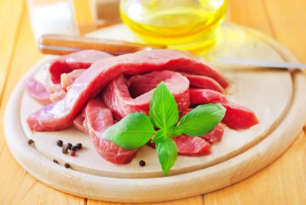 Carne crua sobre placa de madeira — Fotografia de Stock