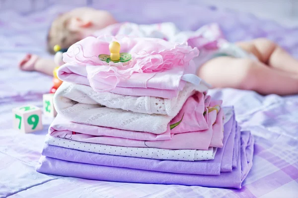 Ropa de bebé en la cama —  Fotos de Stock