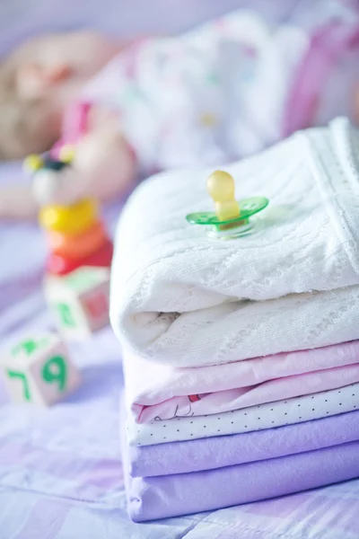 Ropa de bebé en la cama — Foto de Stock