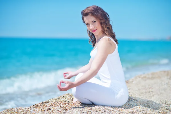 Young woman meditating on the beach — Stock Photo, Image