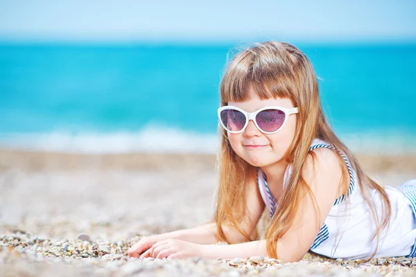 Little girl in sunglasses on the beach — Stock Photo, Image