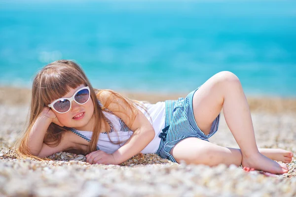 Little girl in sunglasses on the beach — Stock Photo, Image