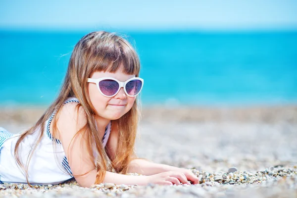 Little girl in sunglasses on the beach — Stock Photo, Image