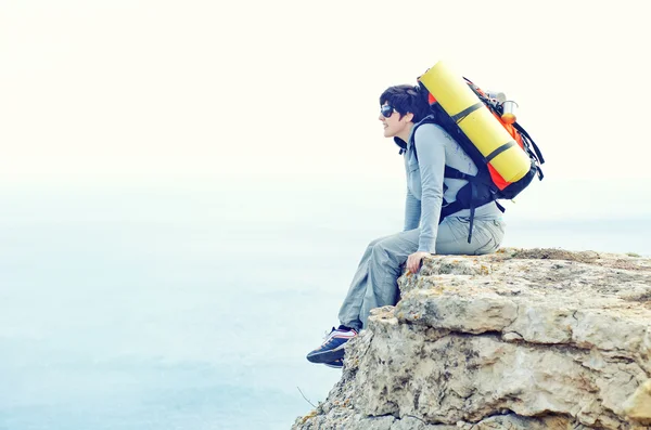 Woman with backpack on cliff — Stock Photo, Image