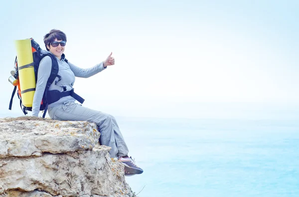 Woman with backpack on cliff — Stock Photo, Image