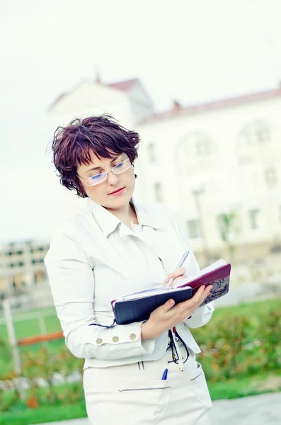 Business woman looking in notebook — стоковое фото