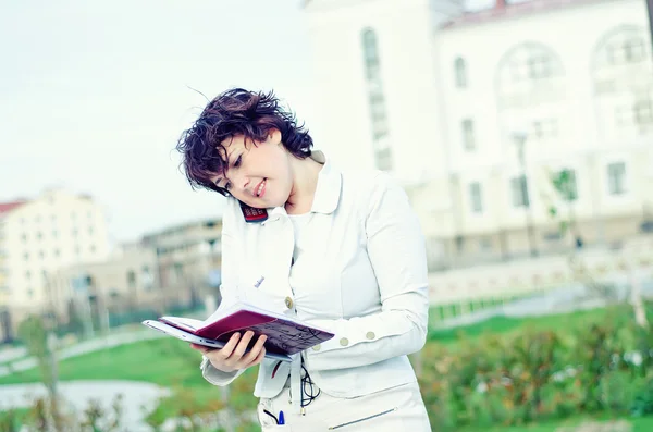 Business woman looking in notebook — стоковое фото