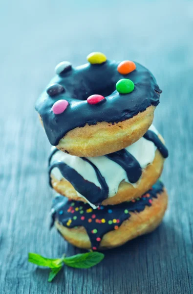 Süße Donuts auf dem hölzernen Hintergrund — Stockfoto