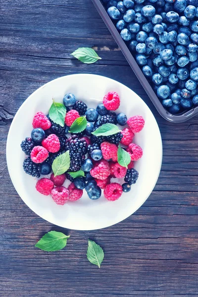 Berries on white plate — Stok fotoğraf