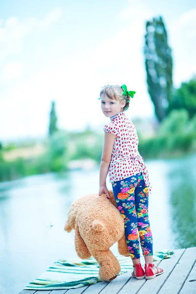 Fille sur jetée avec ours en peluche — Photo