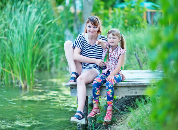 Mother and girl wooden pontoon — Stock Photo, Image