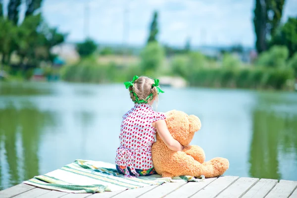 Chica en muelle con osito de peluche — Foto de Stock