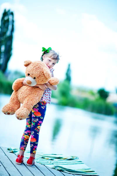 Meisje op pier met teddy bear — Stockfoto