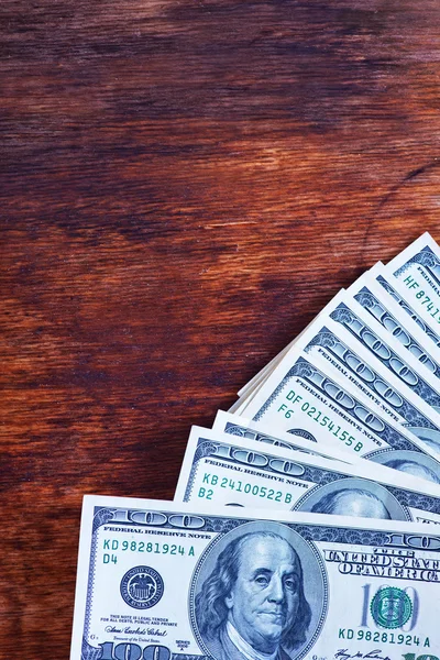 Dollars op houten tafel — Stockfoto