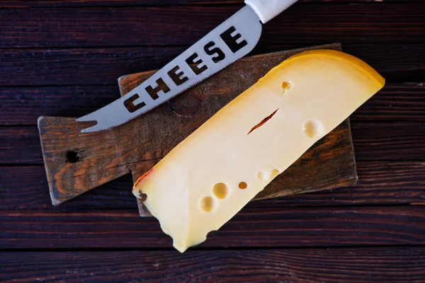 Piece of cheese with knife — Stock Photo, Image