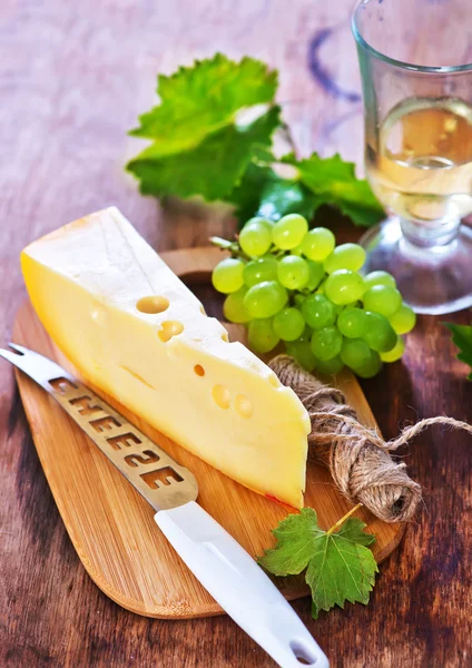 Käse und Trauben an Bord — Stockfoto