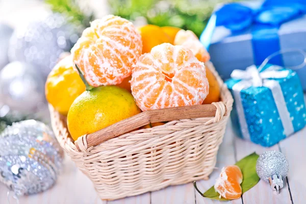 Mandarinas en cesta y sobre la mesa —  Fotos de Stock